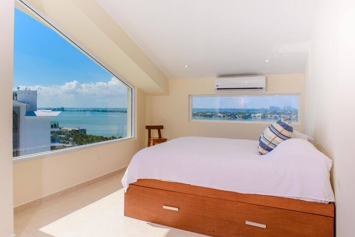 UPDATE: Blackout curtains installed! Wake up to a 180 degree view of water and beach! Upstairs bedroom features massive windows, a king size bed, a pull out queen size bed, full size bathroom and flat screen TV.