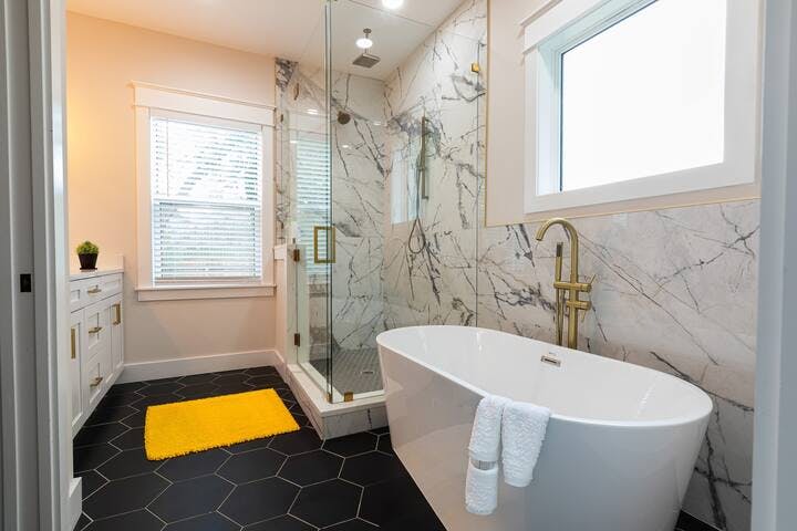 Bathroom 1: Indulge in luxury! Our large ensuite bathroom features designer accents, marble, and a spacious soak-in tub. Enjoy a rejuvenating experience in the huge glass shower with multiple rain spouts. Book your lavish stay now! ✨