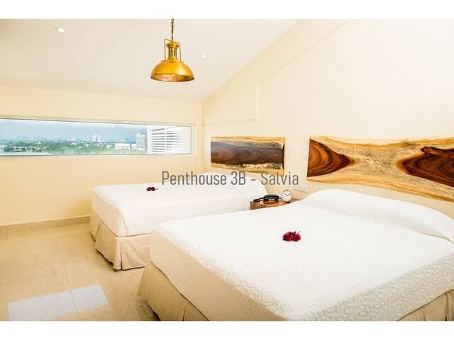 Upstairs bedroom features 2 queen beds and an ocean view on both sides