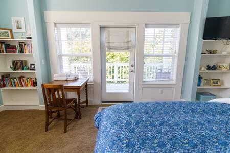 Master bedroom on main floor has a king bed, big deck, desk, and full bathroom.