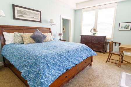 Master bedroom on main floor has a king bed, desk, big deck, and full bathroom.