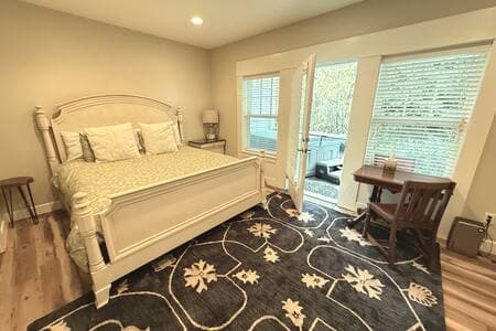 This king bedroom/full bathroom suite has its own entrance, at the ground level, down a flight of external stairs on the side of the house. The hot tub is on the patio outside.