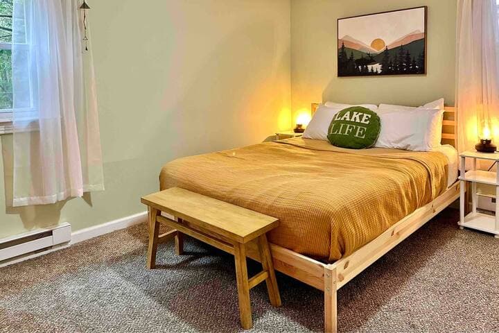 Enjoy views of the forest from this bedroom featuring a queen sized bed