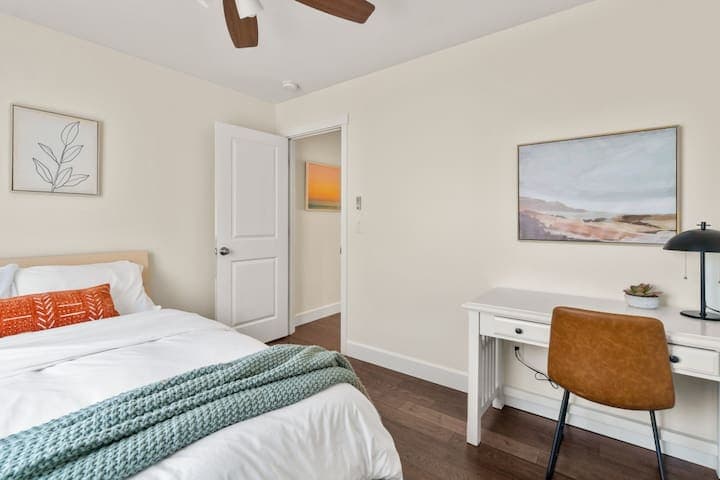 This second floor bedroom with a queen bed and memory foam mattress also doubles as an impromptu office with desk, lamp and chair.