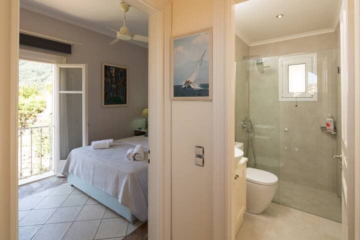 Bedroom 2 on the upper level seen with the adjacent bathroom, which is shared with the other bedroom of this level.