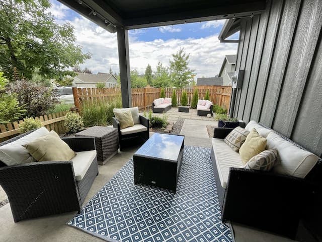 Back porch covered seating area with a coffee table to relax outside.