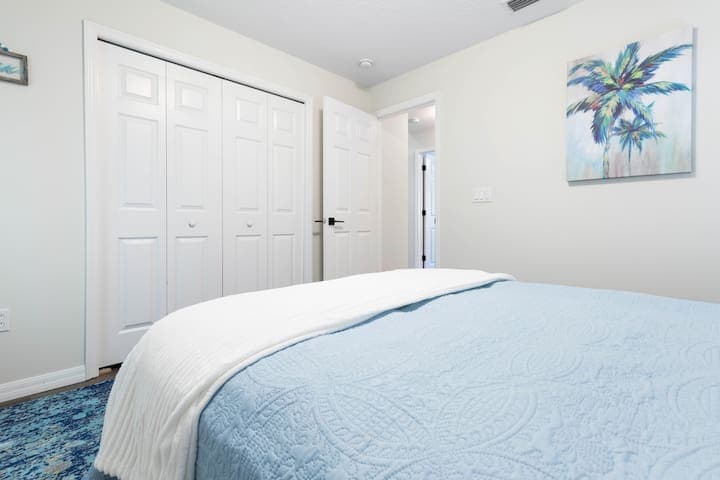 Full closet in the 3rd bedroom decorated in a coastal, palm vibe and aqua decor.