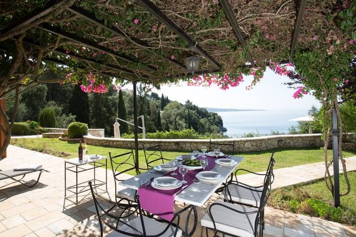 "Al fresco" dining area under the bougainvillea pergola in the main garden, with sea views.