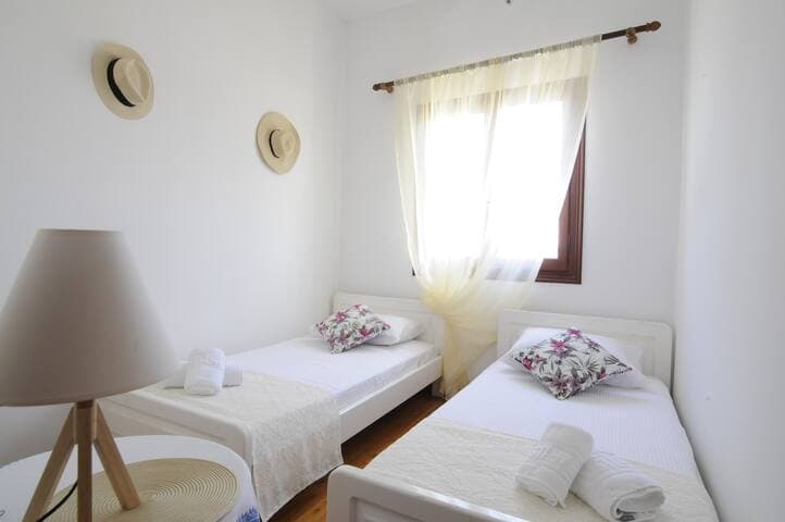 Twin bedroom with wooden wardrobe and window