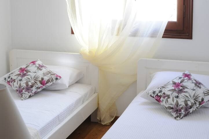 Twin bedroom with wooden wardrobe and window