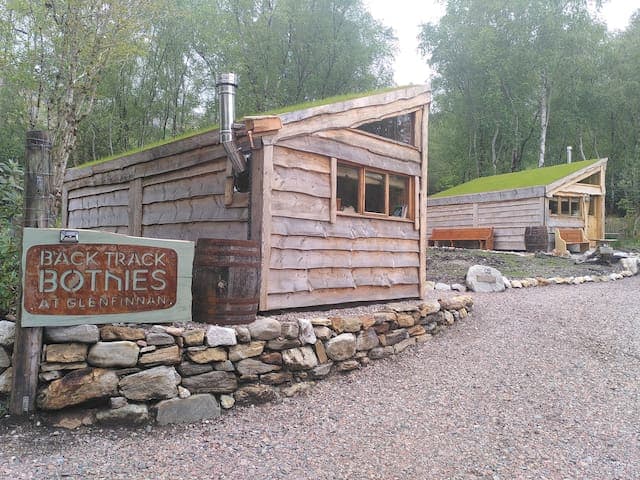Beautiful Clanranald Bothy, at Back Track Bothies in the heart of Glenfinnan. All our Bothies have super-insulating turf roofs and rain chains to drain roof water into whisky barrels. Clanranald is the Bothy right beside the Back Track, a core path