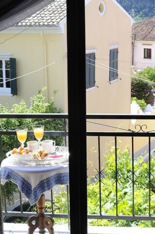 Master bedroom balcony with views towards the village square with an ouzo table and chairs