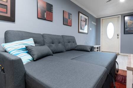 Living Room | Queen Sofa Bed + Storage The couch folds out to a queen-sized bed with a comfortable mattress, much better than typical pull-outs. The chaise stores many extra blankets and pillows for your comfort.