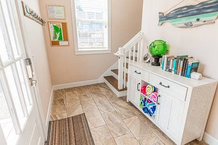 The foyer, with stairs to main floor living, and hallway on the other side, leading to three of the bedrooms and two baths